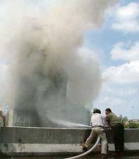 Thick smoke billows out of a building on fire as firefighters try to control the flames in Ludhiana on Monday.