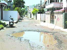 Rainwater fills up potrholes of Hukam Singh Road.