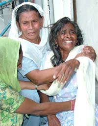 Sister of Mohinder pal, a security guard at a local office of a life insurance company, who was murdered on Tuesday, being consoled by her relatives on Wednesday.