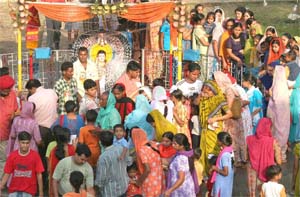 Devotees mill in front of the Baba Sodal idol in Jalandhar on Wednesday Morning.