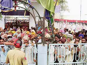 A policeman tries to control the rush of devotees at Chhapar Mela near Mandi Ahmedgarh on Wednesday.