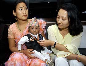 In this picture taken on April 17, 2006, 14-year-old Nepalese boy Khagendra Thapa Magar sits on the lap of his mother Dhana Maya Thapa, at Baglung, 270 km south of Kathmandu