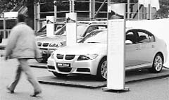 A man walks past a BMW car before the company's annual shareholder meeting in Munich