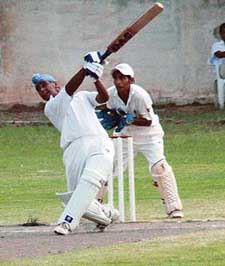 A batsman uses the long handle in the cricket match between Guru Nanak School and Stepping Stones School in Chandigarh
