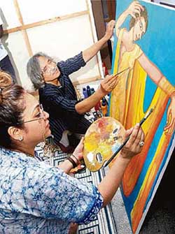 Veteran Bollywood actress and art connoisseur Tina Ambani and eminent artist Jogen Chowdhury give finishing touches on the painting done jointly by them at Jogen Chowdhurys studio at Santiniketan in West Bengal, on Tuesday to raise fund for a Delhi- based NGO working for distress women and children.
