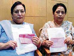 NRIs Prem Brar and Shashi Sharma show proof of ownership of plots bought from the Satluj Co-op House Building Society in Ludhiana on Tuesday.