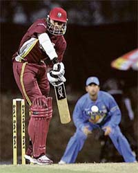 Chris Gayle of the West Indies plays a shot as Sachin Tendulkar looks on during the one-dayer in Kuala Lumpur