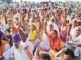 Farmers, including women, of seven villages whose 1,218 acres are being acquired for an SEZ gherao officials of the DLF who went to the site for collecting water samples.