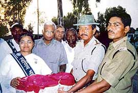 Brahma Kumari Kamlesh from Mumbai, leader of the Swarnim Bharat Yuva Padyatri team, presents a pack of fruits to Border Security Force officials near the Sadaki Indo-Pak border post, in Sulemanki sector, on Friday. 