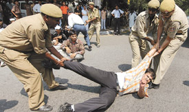 Policemen drag a disabled man during the protest.  