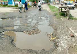 Potholes created in road leading to Urban Estate, Phase I, from Garha Road makes commuters a harried lot.