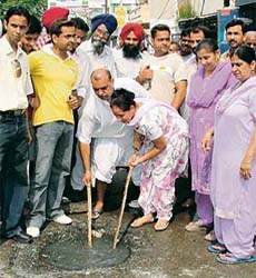 Councillor of Ward No. 47 Sukhchain Bassi Gogi and her husband clean a choked manhole in Ludhiana