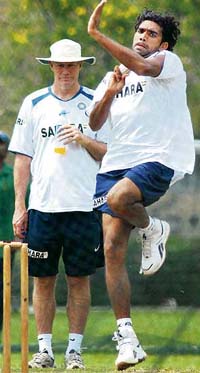 Munaf Patel bowls during a practice session as coach Greg Chappell looks on in Kuala Lumpur