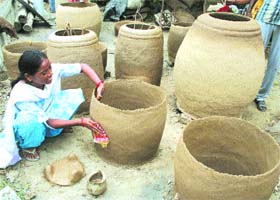 A woman artisan gives finishing touches to a tandoor in Amritsar