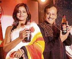 Magician P.C. Sorcar (junior) and a model launch an "apple juice" in Kolkata on Wednesday.