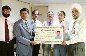 Mr Hemant Contractor, Chief General Manager, SBI, and Mr Jugdiep Singh, Director, SPS Apollo Hospitals, release health cards for SBI customers at a function in Ludhiana on Thursday.