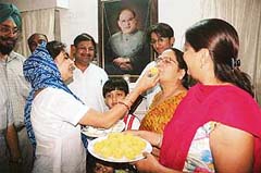 The wife of newly elected president of the Punjab Pradesh Youth Congress, Mr Vijay Inder Singla, offers sweets to her mother-in-law in Patiala