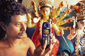 Renowned idol artist Amit Pal making an idol of Goddess Durga by seeing the image on a mobile phone in Kolkata on Saturday. The miniature model will be 1-inch high and 1-inch long