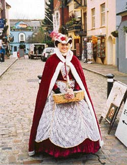 A woman dressed in traditional attire stands in front of the Windsor Castle