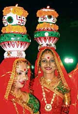Folk dancers from Gujarat carry oil lamps on heads at a garba performance in Ahmedabad late on Sunday. 