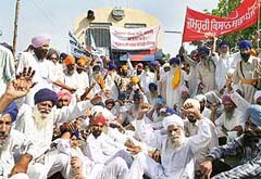 Activists of various farmers’ organisation block rail traffic in protest against the state government’s move to acquire their agricultural land, in Amritsar