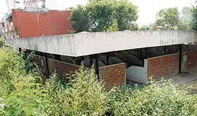 Unoccupied booths for the day market stink of human waste amid an outgrowth of uncleaned vegetable waste in Sector 42
