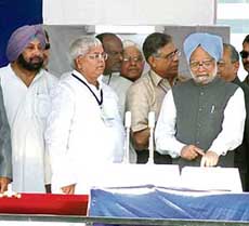 The Prime Minister, Dr Manmohan Singh, presses the button to lay the foundation stone of a dedicated freight corridor at Guru Nanak Stadium in Ludhiana on Wednesday. 