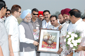 Prime Minister Dr Manmohan Singh being presented a memento by local Congress leaders on his arrival at Halwara Airport in Ludhiana