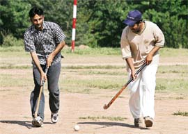 Pakistani youths play hockey on a grass turf in Islamabad.