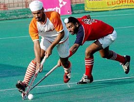 A Punjab Police player (right) fights for the ball with a Namdhari XI player during the quarterfinal of the SN Vohras All-India Gurmit Memorial Hockey Tournament at the Sector 42 hockey stadium in Chandigarh on Saturday. Namdhari XI won 1-0