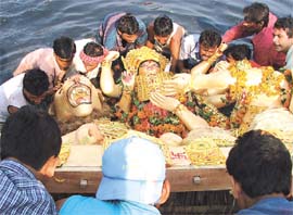 A Durga idol being carried by devotees for immersion in the Yamuna in the Capital on Monday.