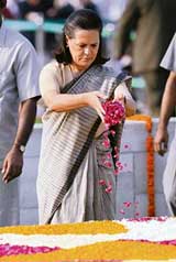 Congress President Sonia Gandhi offers rose petals while paying tributes to Mahatma Gandhi at Rajghat in Delhi on Monday
