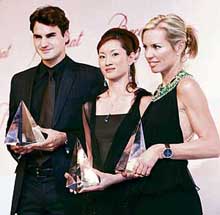 World No. 1 tennis player Roger Federer (L) of Switzerland, Turin Olympic figure skating gold medallist Shizuka Arakawa (C) of Japan and seven-summit womens fastest climbing world record holder Annabelle Bond of the UK hold their trophies during a ceremony for the Athletes of the Year Award 2006 in Tokyo on Monday.