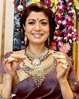Bengali actress Debasri Roy displays a jewellery piece at the anniversary celebrations of a showroom in Kolkata