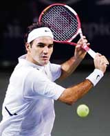 Switzerlands Roger Federer plays a return to South Africas Wesley Moodie during their third-round match at the Japan Open tennis championship in Tokyo on Thursday