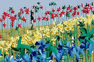 A girl walks along an art installation made up of weathercocks, wishing for peace on the Korean peninsular