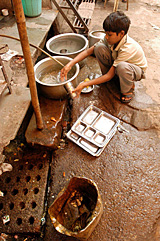 A child cleans utensils at a food stall. The ban on child labour will come into force from Tuesday.