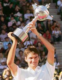 Switzerlands Roger Federer raises the trophy after winning the Japan Open tennis championship at Ariake tennis court in Tokyo