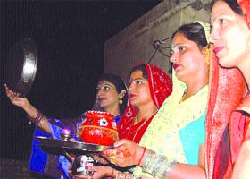 Married women try to catch a glimpse of the moon on the occasion of Karva Chauth in the Capital