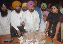 Mr Balwant Singh Ramoowalia, President, Lok Bhalai Party, shows the money to mediapersons in Jalandhar on Tuesday. The money was received from the in-laws of a divorcee.