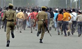 Policemen chase away students of Kashmir University during a protest against the death sentence of Afzal Guru in Srinagar on Tuesday.