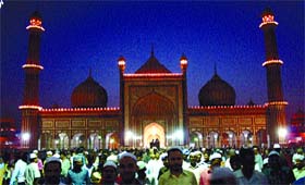 People mill around in front of Jama Masjid after breaking a daylong fast in keeping with the holy month of Ramzan