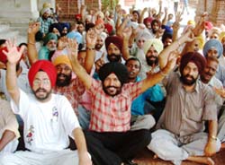 Non-teaching employees of Khalsa College, Amritsar, stage a dharna in the college on Thursday