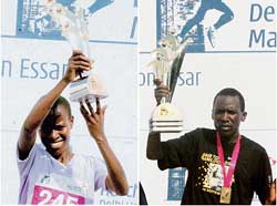 Kenyas Lineth Chepkirui and her compatriot Francis Kibiwott hold the trophies after winning the womens and mens titles, respectively, of the Delhi Half Marathon in the Capital on Sunday