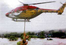 An advanced light helicopter of the IAF is winching a woman and her child at Nanded in Maharashtra in the recent flood relief operations