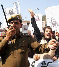 A police officer stops Democratic Freedom Party chief Shabir Ahmad Shah during a protest against the death sentence of Mohammad Afzal Guru, in Srinagar
