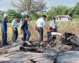 Air force personnel inspect the remains of the MIG-27 fighter plane that crashed into a field near Kadamtala in West Bengal on Thursday.