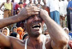 A man cries after losing a relative in a ferry accident, on the bank of the river Meghna, 40 km from Dhaka