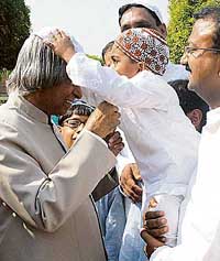 President A.P.J. Abdul Kalam is offered a cap by a child on the occassion of Id-ul-Fitr at Rashtrapati Bhavan in New Delhi on Tuesday. 
