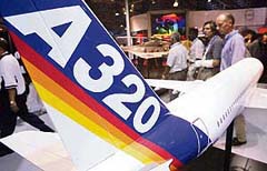 Visitors walk past a model of an Airbus A320 plane on display at the Asian Aerospace 2004 show in Singapore 
